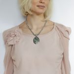Pandantiv Paua Shell fațetat pe un șnur de lănțișoare.
